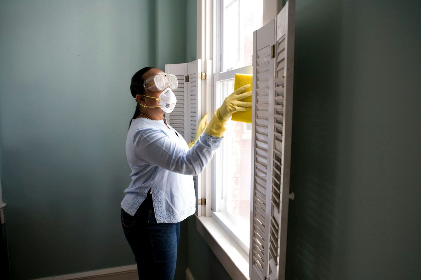 Aven Cleaning Co. cleaner wiping window shutters