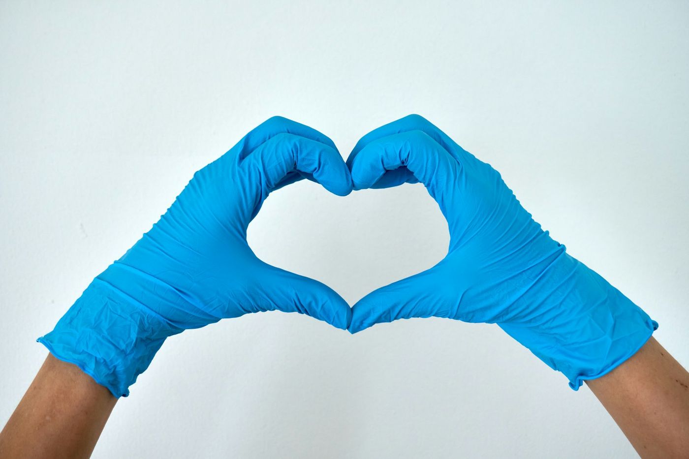 Cleaner making a heart shape with gloved hands