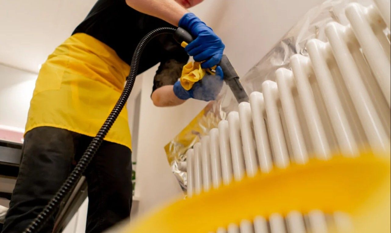 Cleaner steam cleaning a radiator during a deep cleaning